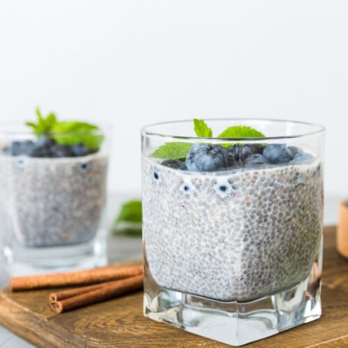two glasses of coconut chia pudding with cinnamon and blueberries